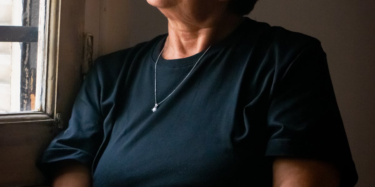Reife Frau am Fenster, nachdenklich